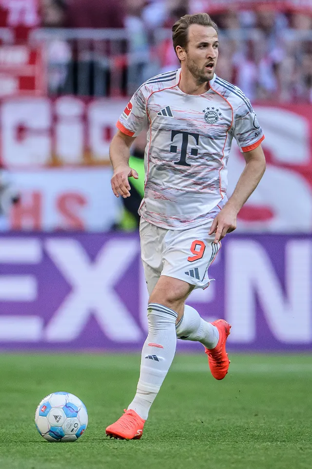 Harry Kane mit dem Ball am Fuß im weißen Trikot scannt das Spielfeld. (Foto)