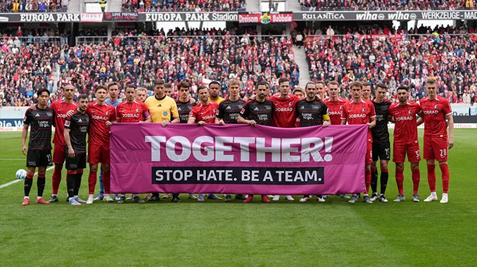 Die Mannschaften vom 1. FC Union Berlin und dem SC Freiburg halten gemeinsam ein Banner mit der Aufschrift: "TOGETHER! STOP HATE. BE A TEAM." hoch. (Foto)