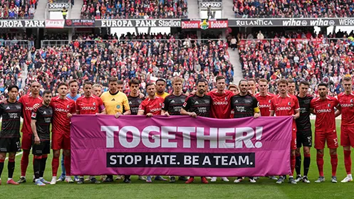 Die Mannschaften vom 1. FC Union Berlin und dem SC Freiburg halten gemeinsam ein Banner mit der Aufschrift: "TOGETHER! STOP HATE. BE A TEAM." hoch. (Foto)