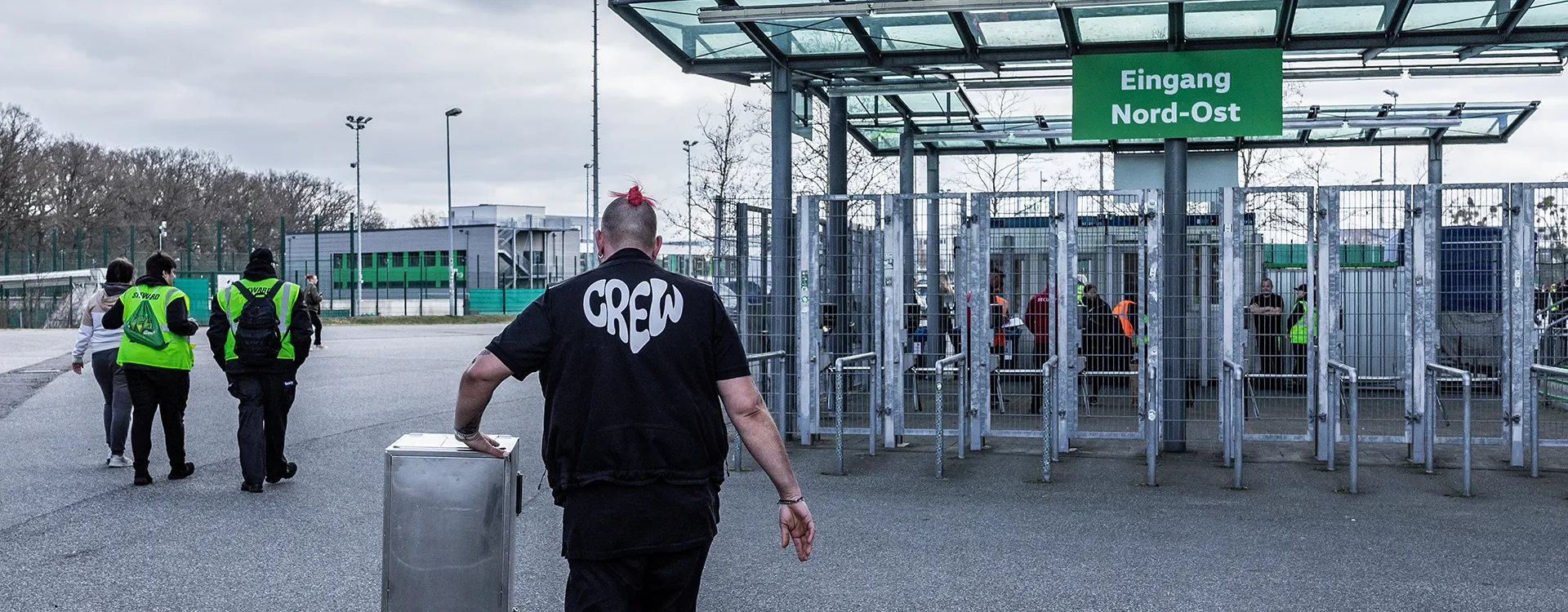 A man with the word ‘Crew’ printed on his shirt pushes a silver box. (Photo)